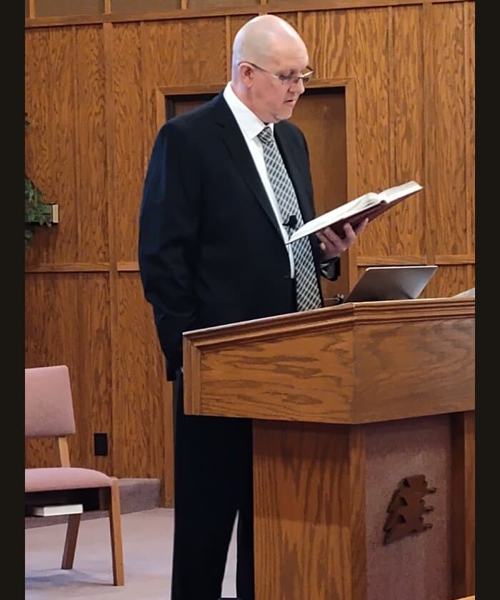 Wylie reading Scripture at the pulpit